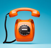 Ein orangenes Telefon, das klingelt.