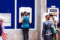 Eine Frau hebt Geld am Geldautomaten ab