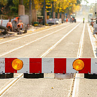 Foto einer Warnschranke sowie Gleise einer Straßenbahn