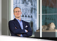 Ein Mann im Anzug schaut in die Kamera.