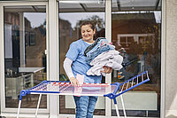 Eine Haushaltshilfe hängt Wäsche auf