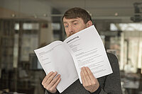 Ein Mann liest seinen Arbeitsvertrag