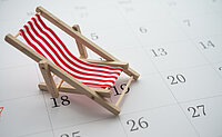 Ein Mini-Liegestuhl steht auf einem Kalenderblatt