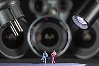 Diverse Miniaturfiguren, die vor mehren Kamera-Objektiven stehen.