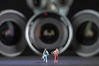 Diverse Miniaturfiguren, die vor mehren Kamera-Objektiven stehen.