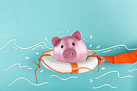 Sparschwein schwimmt im Rettungsring.