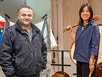 Zwei Menschen mit Migrationshintergrund in unterschiedlichen Berufen: links ein Arbeiter in Arbeitskleidung vor einer Industrieanlage, rechts eine Musikerin im Proberaum