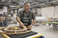 Hikmat Hanan bearbeitet ein Steuerrad auf einer Werft in Bremen-Nord mit Schleifpapier