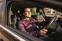 Eine Frau im Auto auf dem Weg zur Arbeit