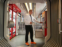 Mann in einer leeren Straßenbahn kontrolliert etwas.