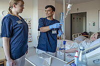 Aref Azizi macht eine Ausbildung zur Pflegefachkraft am Bremer St. Joseph-Stift. Hier ist er im Gespräch an einem Patientenbett.