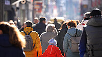 Eine Menschenmenge in einer deutschen Innenstadt mit einem Kind und Menschen unterschiedlichen Alters
