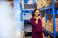 Eine schwangere Frau bei der Arbeit in einer Lagerhalle